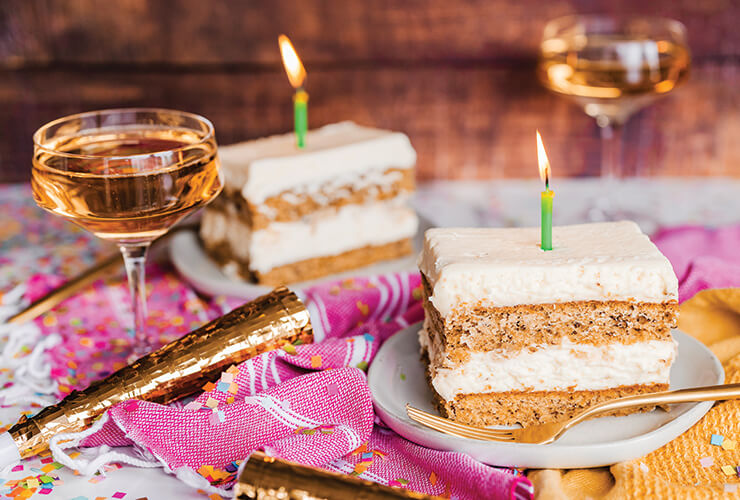 Two New Seasons Market banana cake slices with a lit candle in the top of the slices