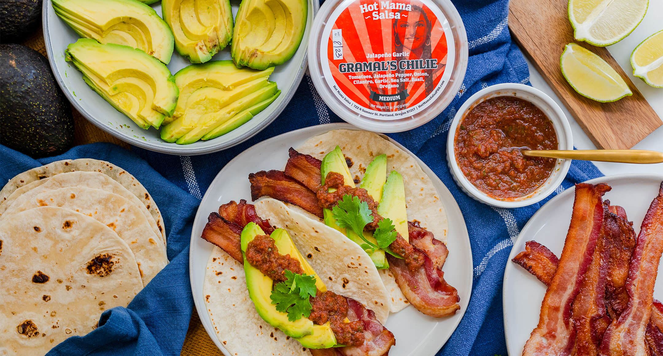 A colorful arrangement featuring fresh tortillas with bacon, avocado, and Hot Mama Gramal's Chilie Salsa. 