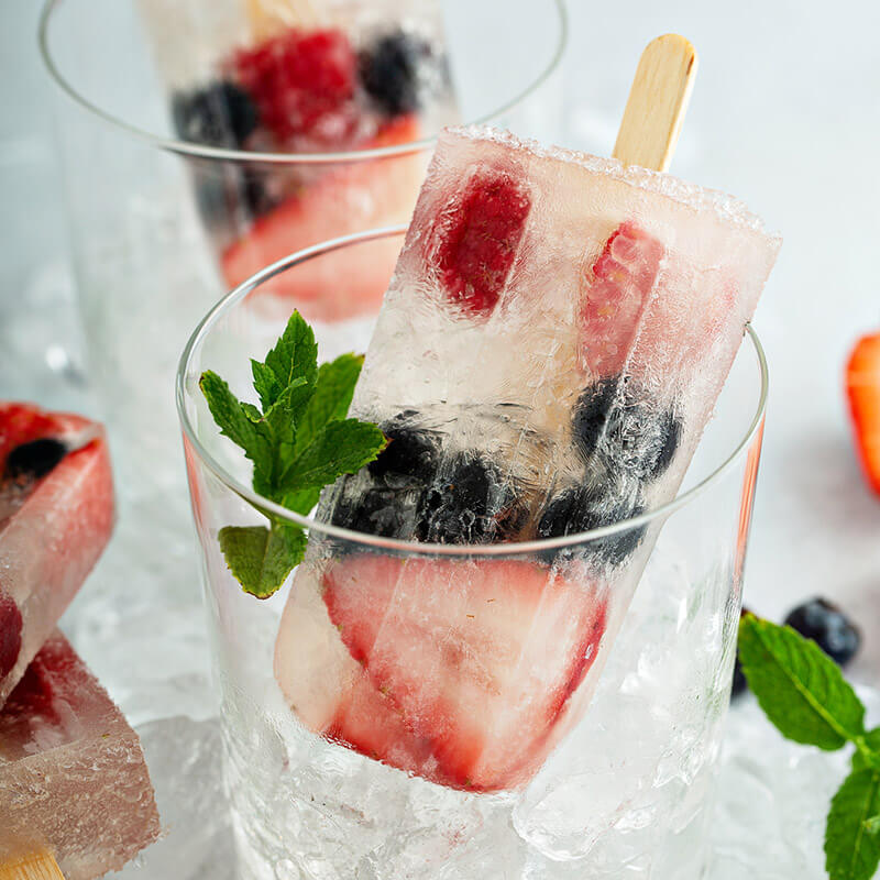 a popsicle with strawberries and blueberries frozen inside 