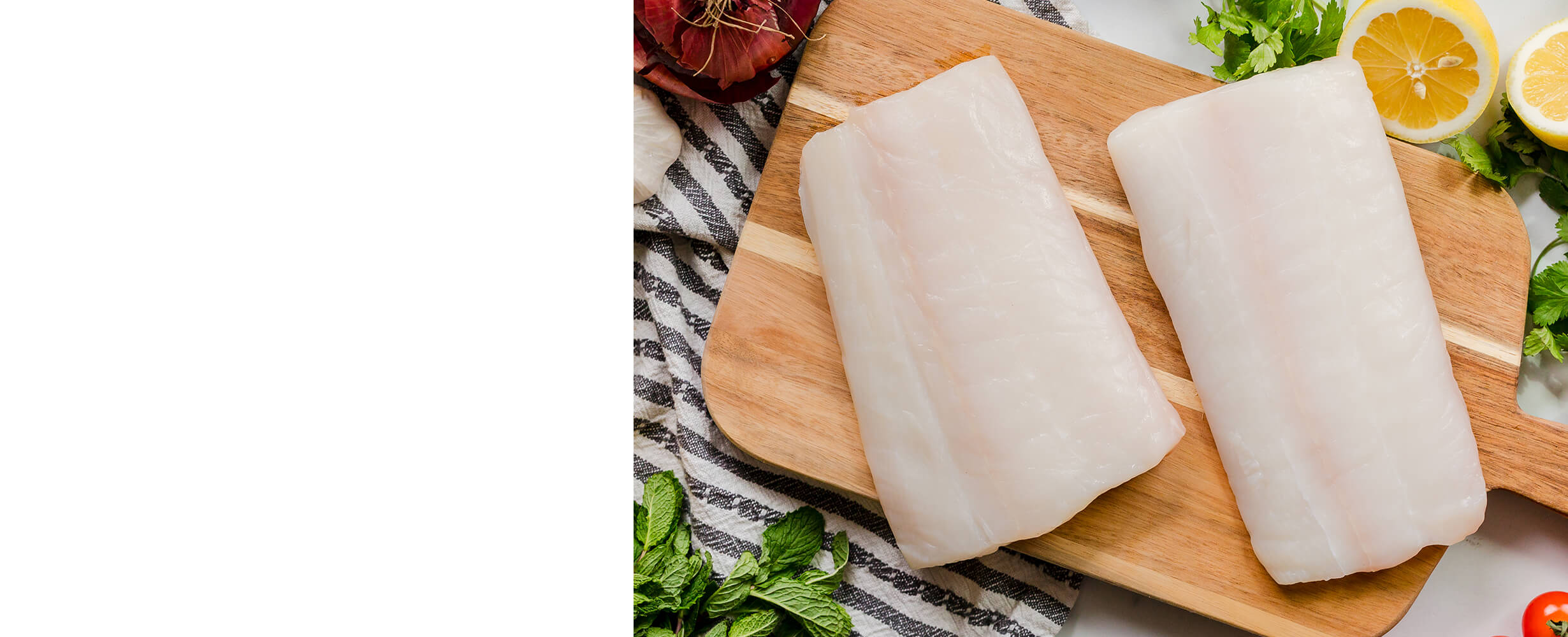 A top down image of 2 halibut fillets on a wood cutting board.