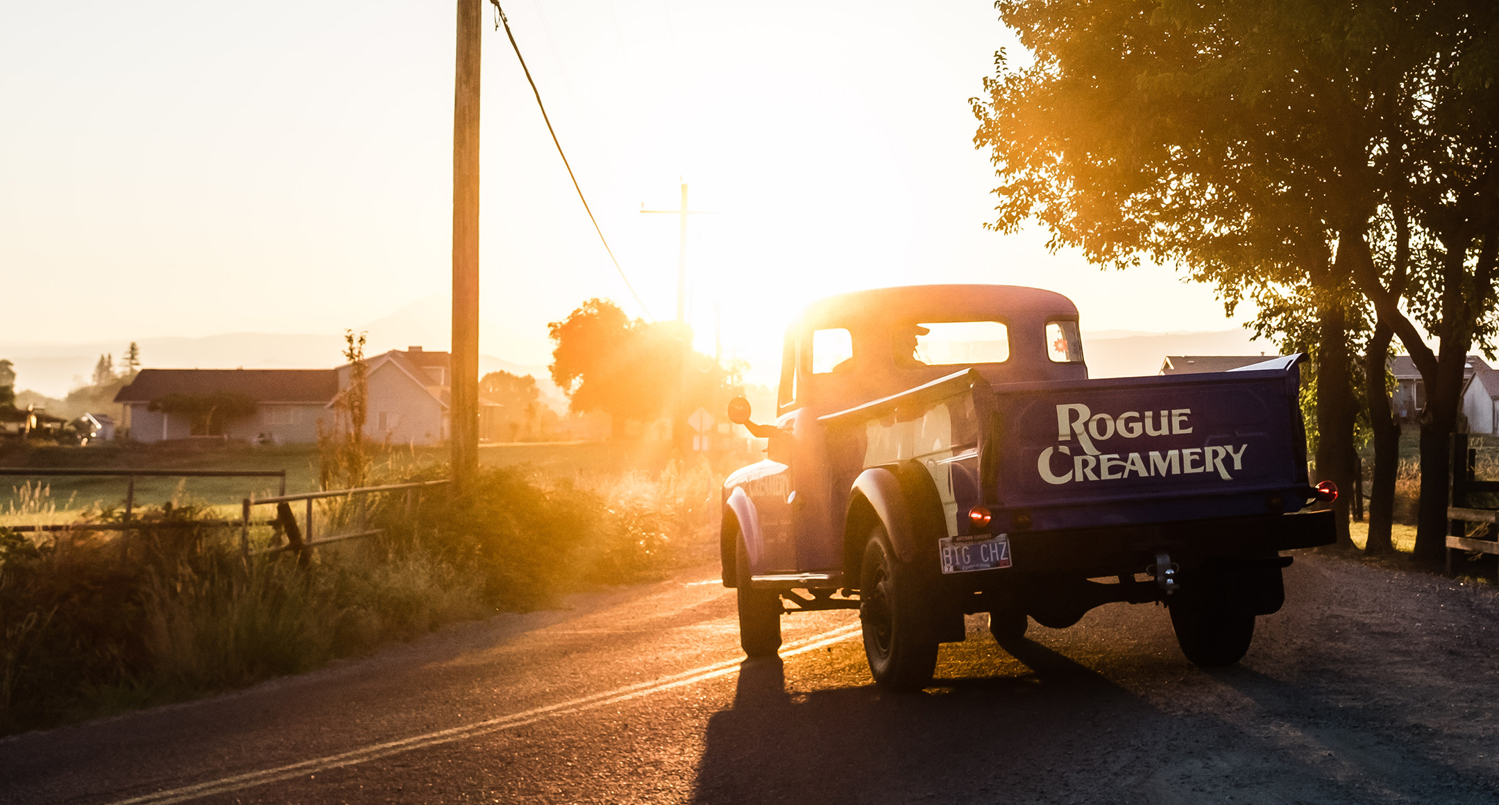 An older model pickup truck with the Rogue Creamery logo on the back