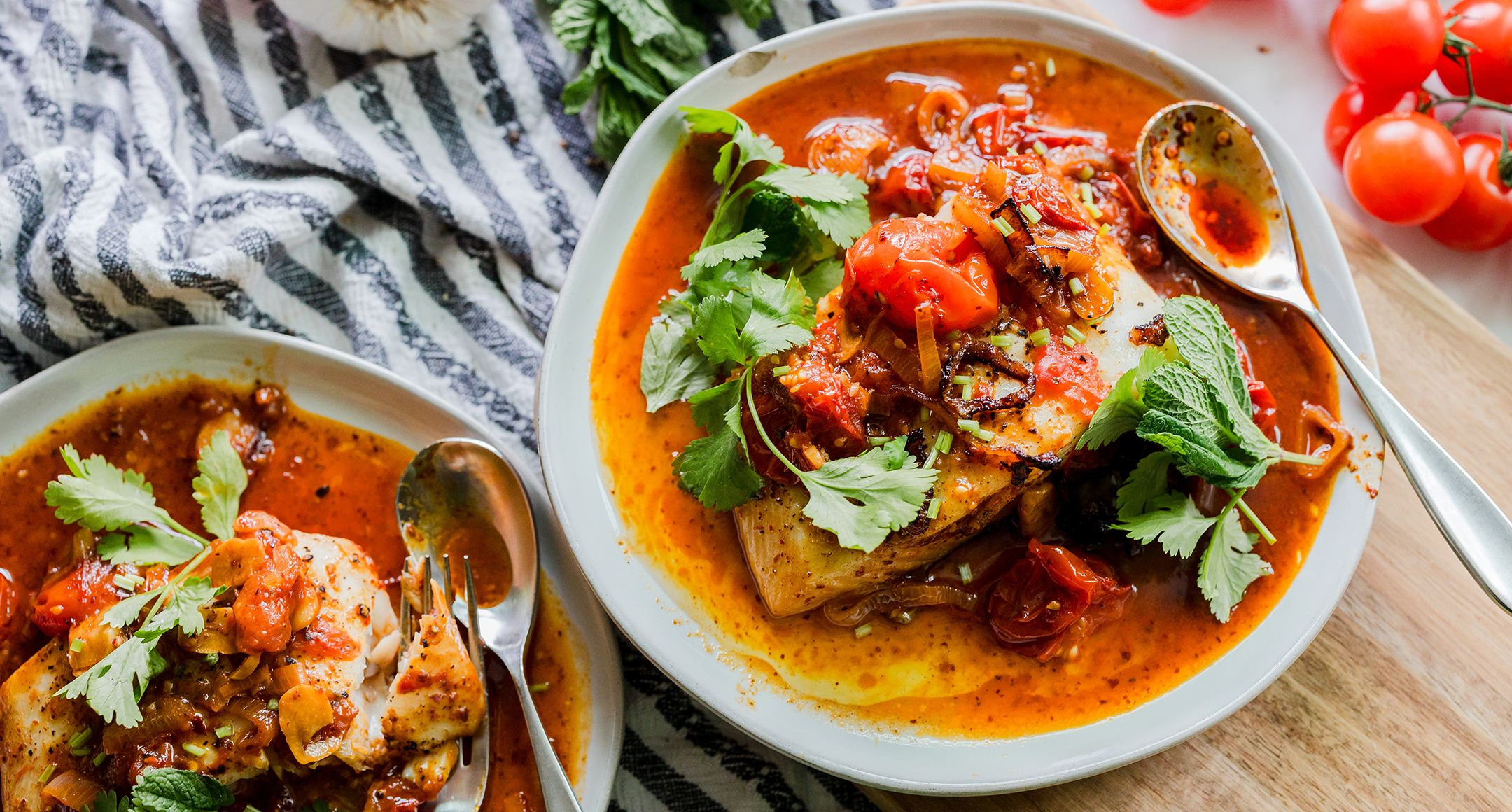 Poached halibut with tomato sauce on a plate.