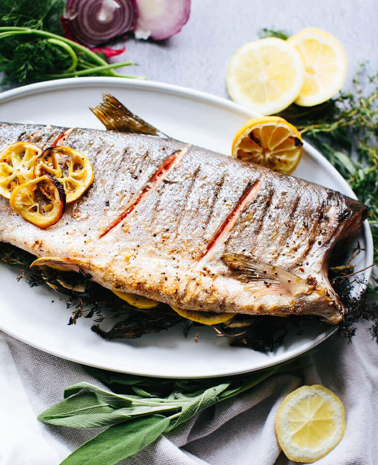 a photo of a grilled whole salmon on a platter.