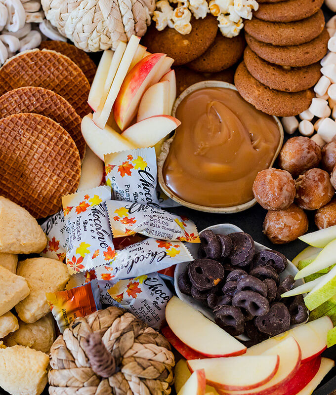 a fall themed selection of sweets and treats including apples, cookies, candy, caramel and more!