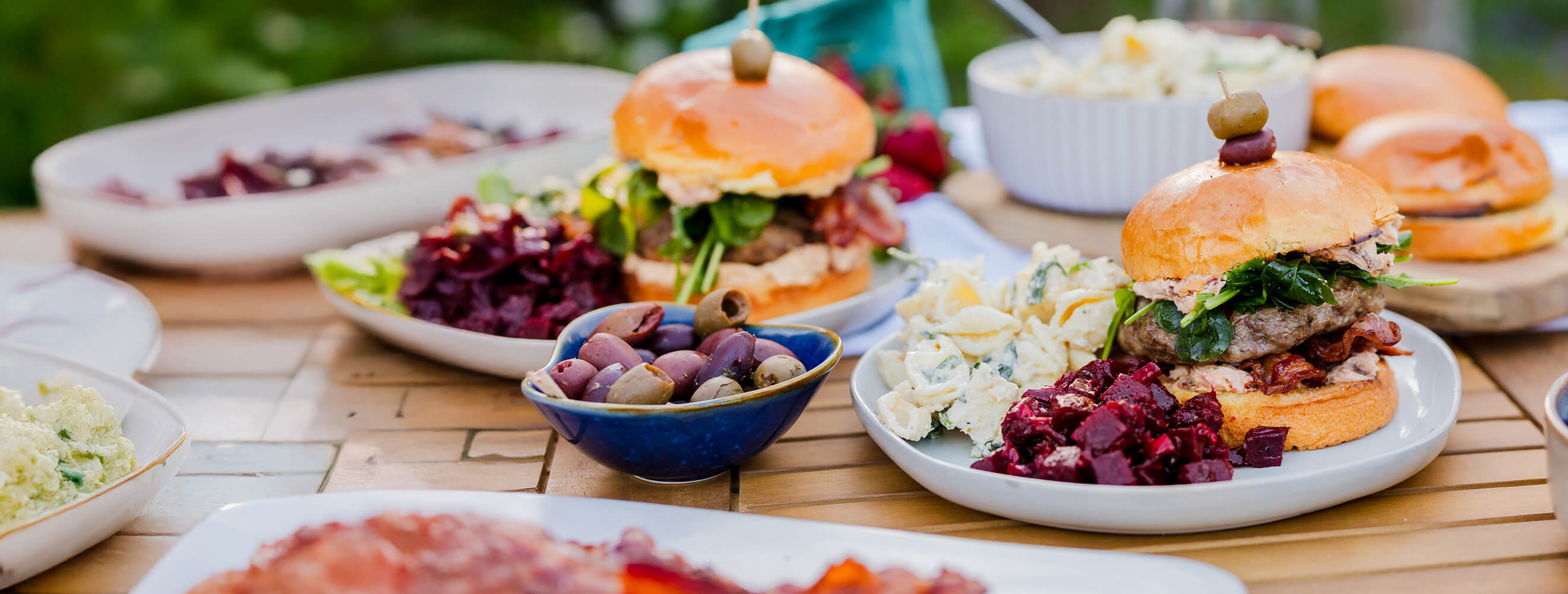 A burger on a bun with seasonal side salads.