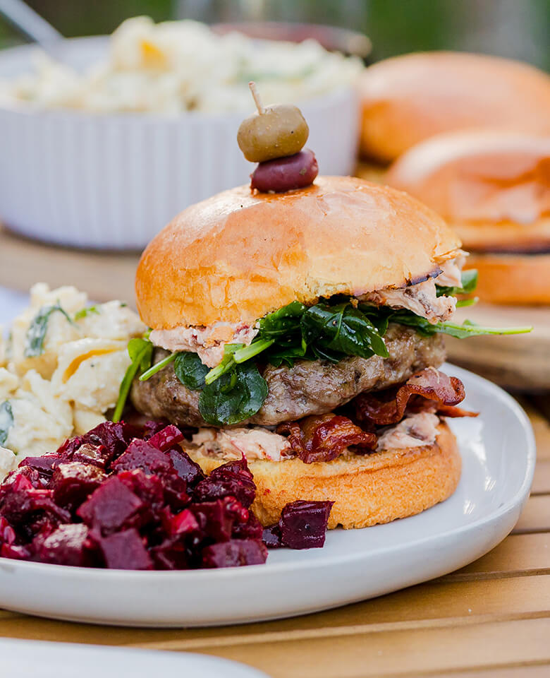 A burger on a bun with seasonal side salads.