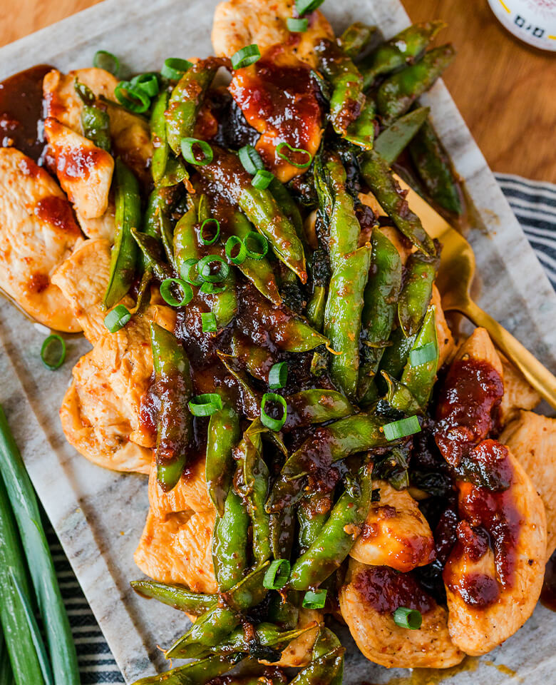 A plate of chicken and snap pea stir-fry featuring Nong's Khao Man Gai Sauce.