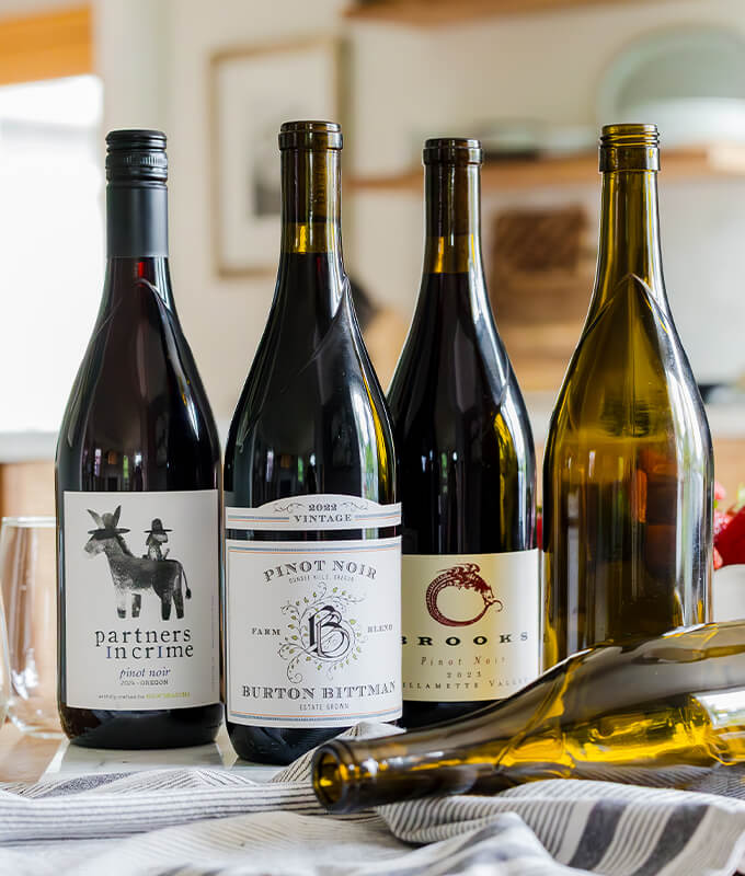 A shot of 5 Revino wine bottles including Partners in Crime, Pinot Noir, and Brooks.