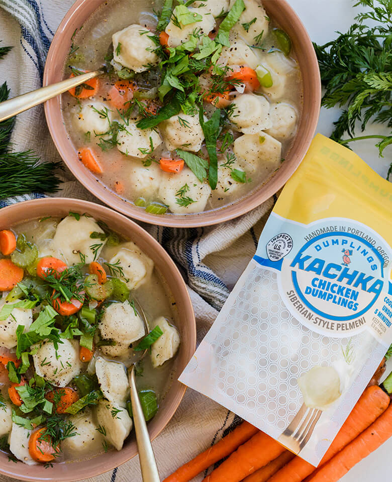A bowl of Kachka chicken dumpling soup next to a bag of frozen Kachka dumplings.