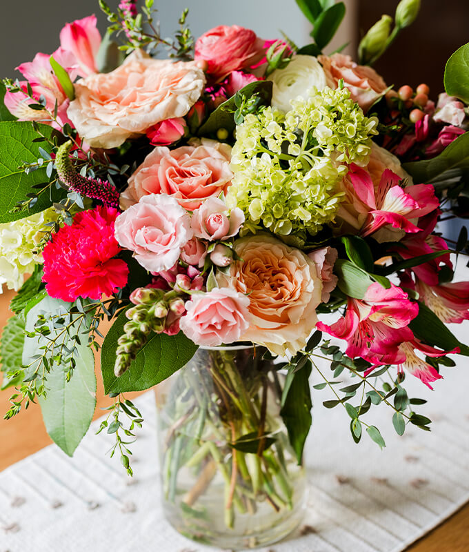 An image of a bouquet of flowers in a vase on a table for mother's day.