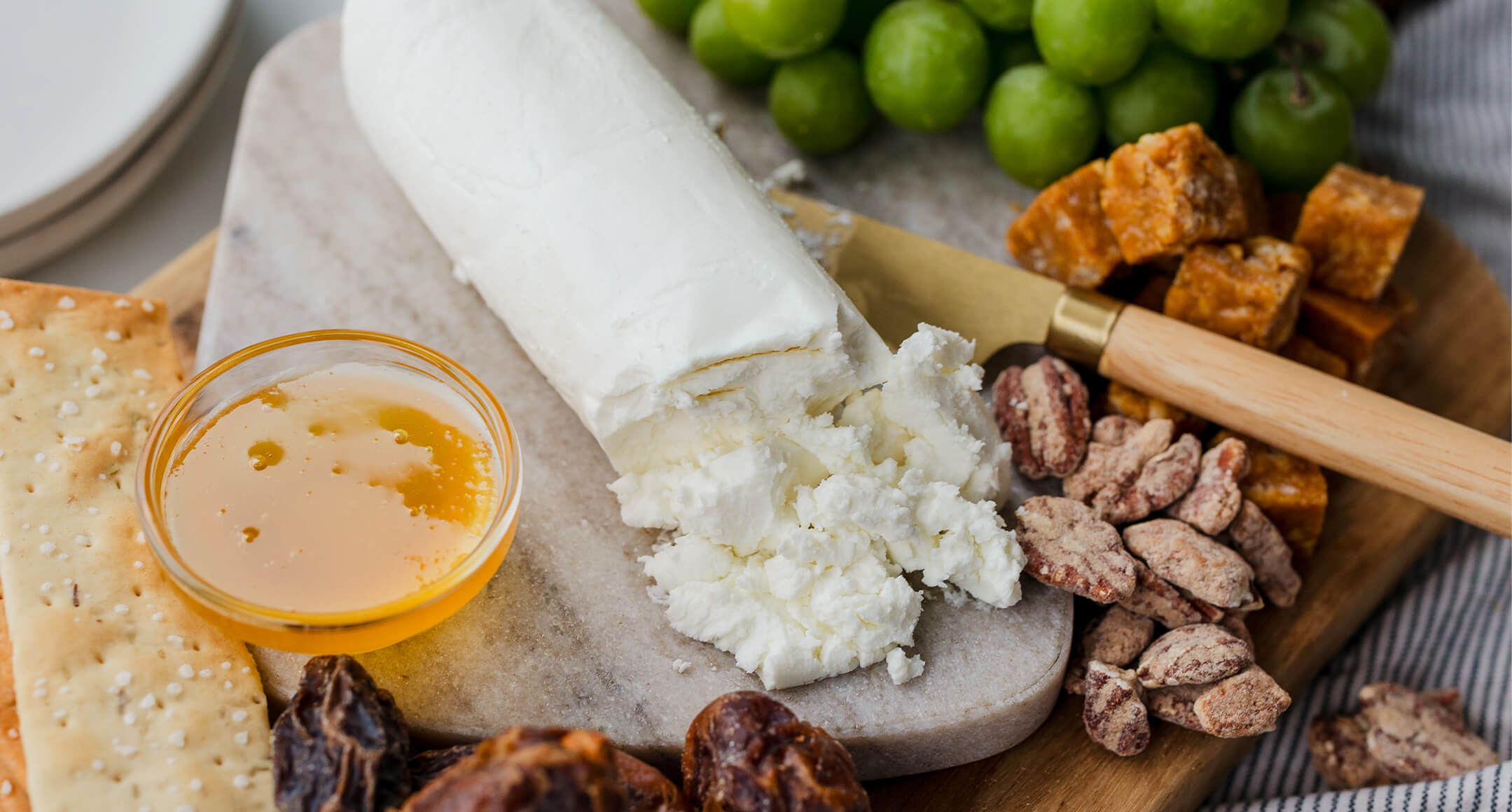 A log of Lost Peacock Creamery chevre on a cheese board.